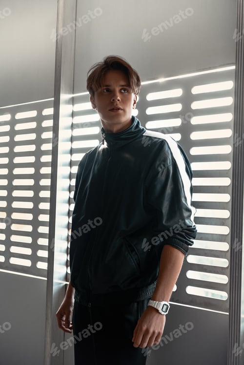 Preview: Young sportive man runner posing near window
