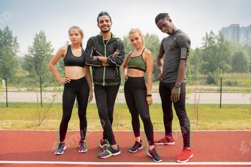 Preview: Row of happy young intercultural friends in activewear looking at you