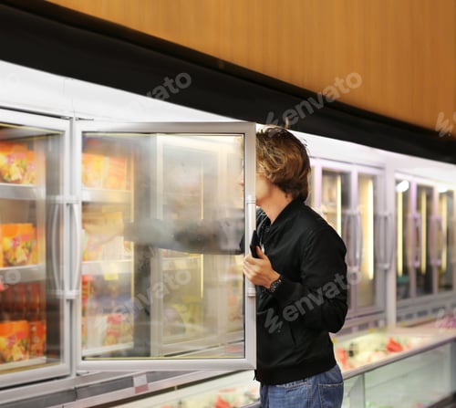 Preview: Teenager Choosing Frozen Food From A Supermarket Freezer