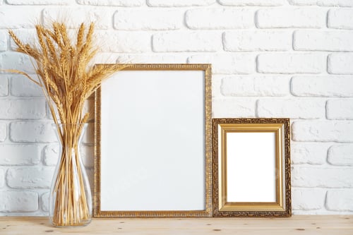Preview: Vase with ears of wheat and photo frames against brick wall