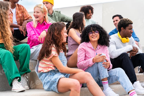 Preview: Happy playful multiethnic group of young friends bonding outdoors