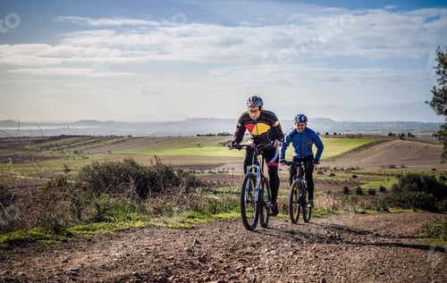 Preview: Two male mountain bikers cycling up dirt track, Cagliari, Sardinia, Italy