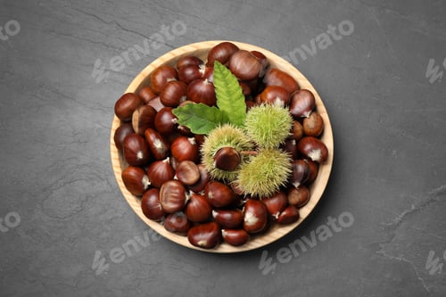Preview: Fresh sweet edible chestnuts on black slate table, top view