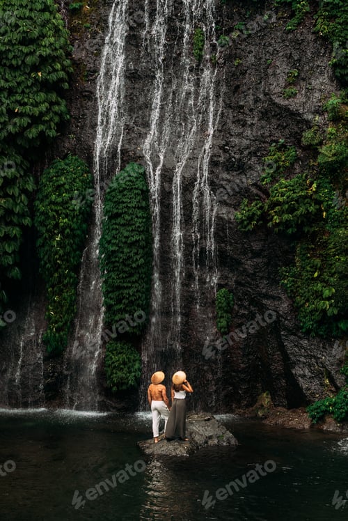 Preview: Lovers at the waterfall. Couple admiring a beautiful waterfall in Indonesia