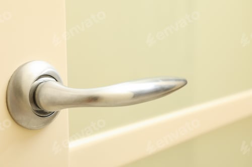 Preview: Metal handle of white door in room