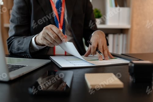 Preview: a businessman is reviewing accounting and financial statistics documents in his private office