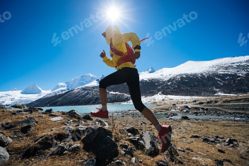 Preview: Woman trail runner cross country running in high altitude winter nature