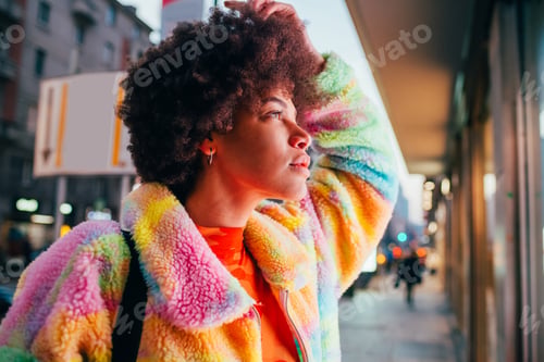 Preview: Young curly hair black woman outdoor watching window shopping at night