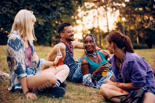 Preview: Multiracial group of happy festival goers relaxing in the park.