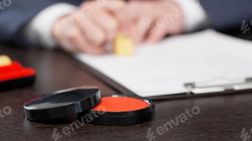 Preview: The hands of a businessman stamping a contract