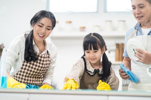Preview: Asian young family teaching their daughter to clean kitchen counter.