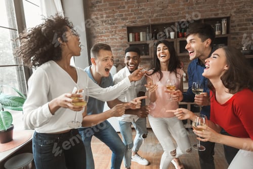 Preview: Excited young people singing and drinking at home party