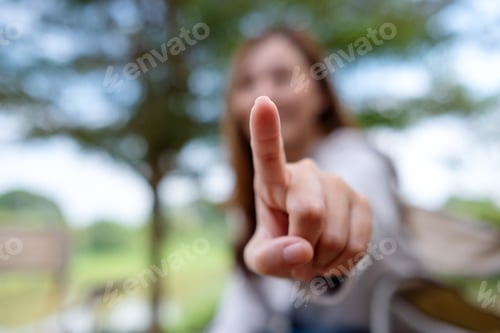 Preview: Blurred image of a woman touching or pointing finger at you