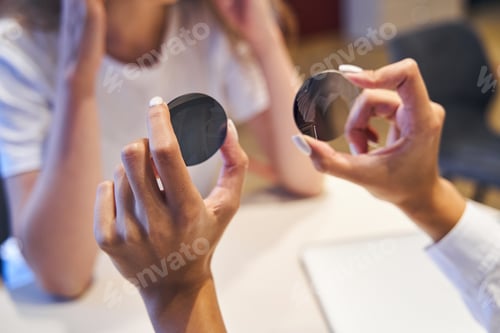 Preview: Female optician hands holding round lenses for eyeglasses