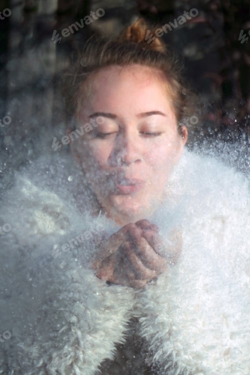 Preview: Girl in the furry coat blowing the snow.