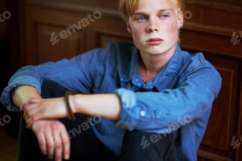 Preview: Brooding youth. Thoughtful and handsome young blonde guy with very blue eyes.