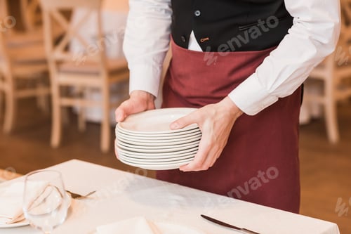 Preview: Cropped image of Waiter putting pile of plates on the table