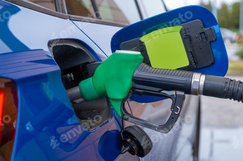 Preview: Refilling of blue modern car at petrol station with gasoline.