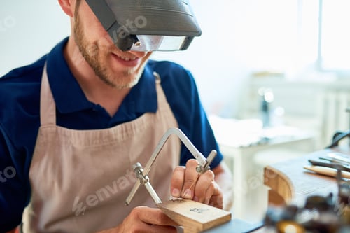 Preview: Smiling Craftsman Making Rings in Workshop