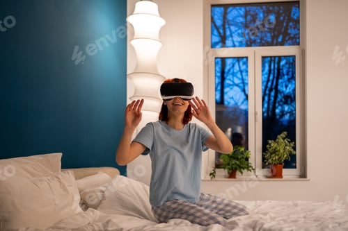 Preview: Woman using virtual reality headset in bedroom