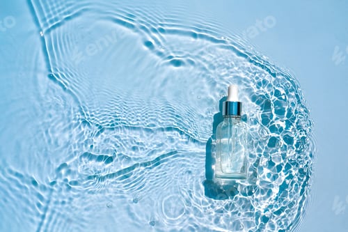Preview: Moisturizing cosmetic serum in transparent bottle with a dropper in water waves, blue background