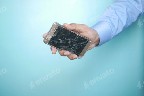 Preview: Close up of man hand holding broken smart phone.