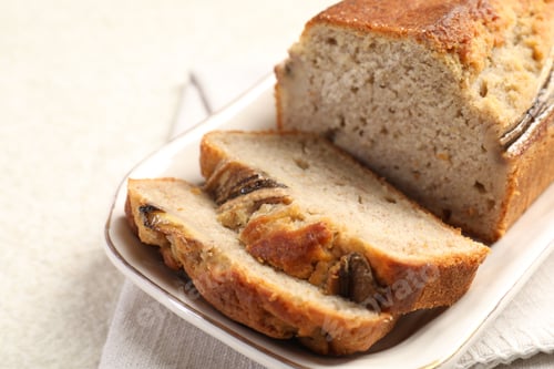 Preview: Pieces of banana bread on light grey table, closeup