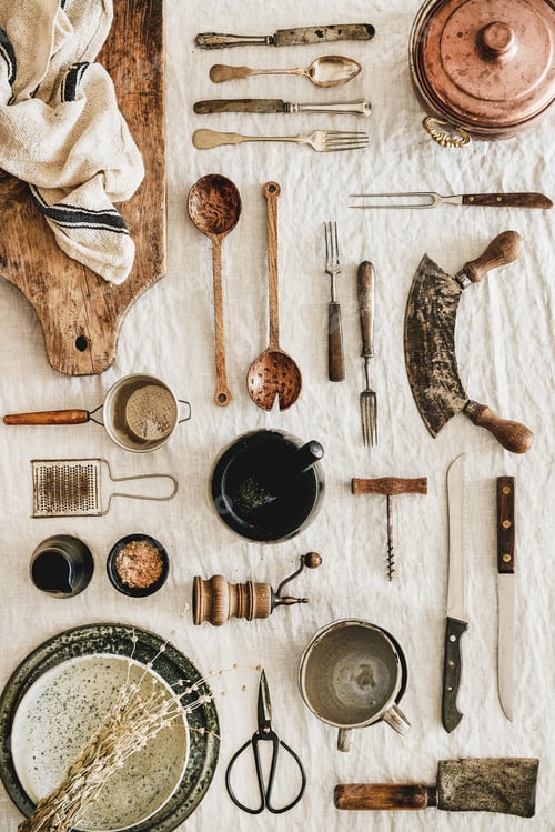 Preview: Various kitchen utensils and tablewear over linen tablecloth, vertical composition