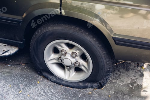 Preview: Destroyed blown out tire with exploded, shredded and damaged tire on a modern automobile.