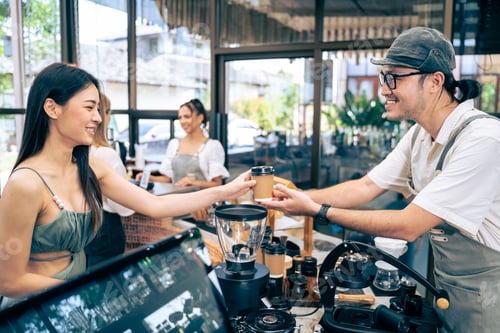 Preview: Asian attractive women receive hot coffee from waiter in coffee house.