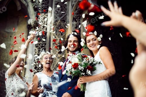 Preview: Family throwing rose petals at the newly wed bride and groom
