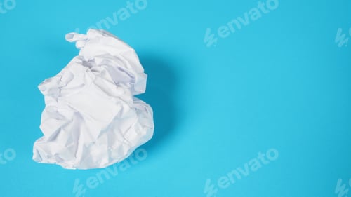 Preview: Crumpled white paper.It is mauled on sky blue background.