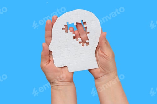 Preview: Two hands hold a white human-head puzzle piece with a gap