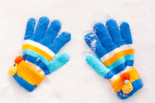 Preview: children's mittens are lying on the snow.