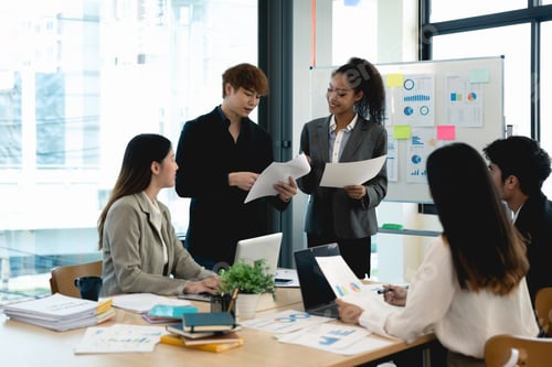 Preview: Group of diverse colleagues discussing for financial report with presentation on flipchart during a