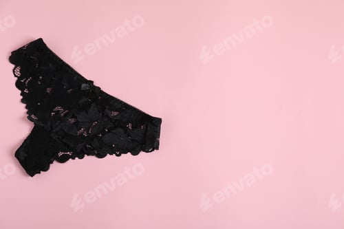 Preview: Women's underwear. Beautiful black panties on pink background, top view. Space for text