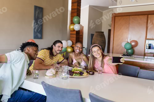 Preview: Friends gathering at home, smiling and taking selfie around dining table