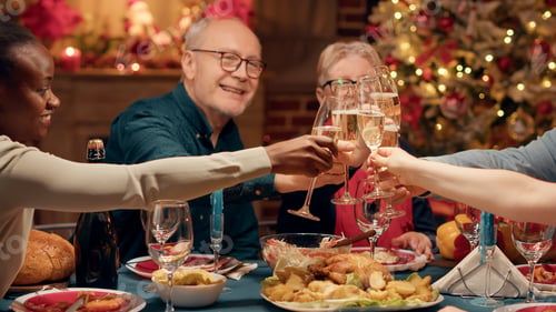 Preview: Cheerful close relatives enjoying winter holiday together while drinking sparkling wine