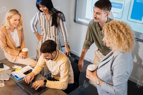 Vista previa: Grupo de empresarios sentados en una sala de reuniones discutiendo el diseño de una aplicación para teléfonos inteligentes.