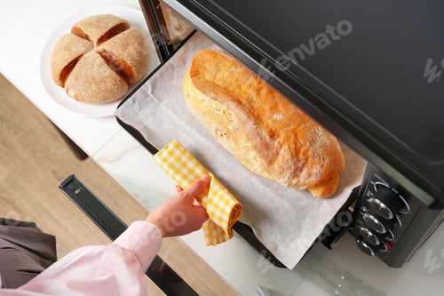 Preview: Woman's hands taking fresh bakery out of mini oven