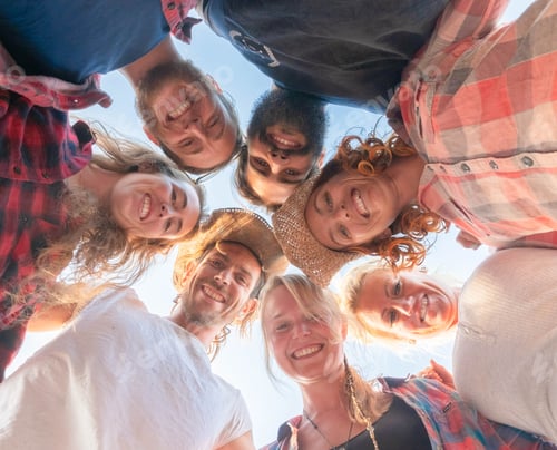 Preview: group of seven people looking at the camera on the ground - people in circle smiling