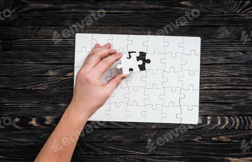 Preview: Completing Puzzle on Dark Wooden Surface Close Up