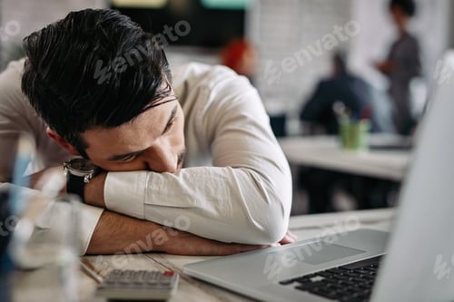 Preview: Exhausted businessman feeling tired after working on a computer in the office.