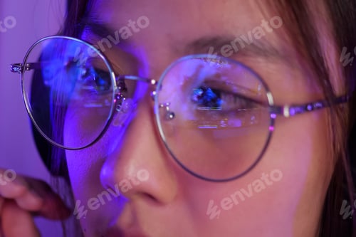 Preview: Female gamer wearing glasses for reducing eye strain blurred vision at home