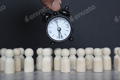 Preview: Alarm clock and wooden dolls on black background.
