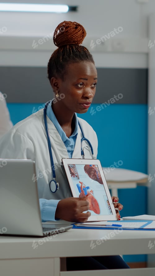 Preview: Young medic holding tablet with medical cardiogram