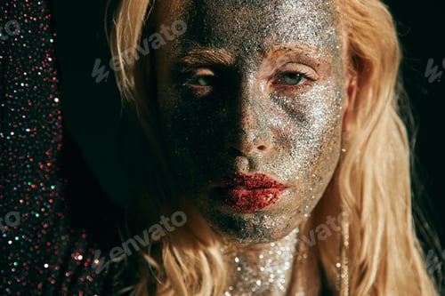 Preview: portrait of good looking woman with red lips and glitter in black elegant dress looking at camera