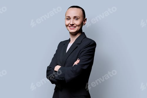 Preview: Portrait of smiling business 30s woman with crossed arms on grey background