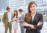 Preview: Businesswoman Smiling with Team in Urban Setting