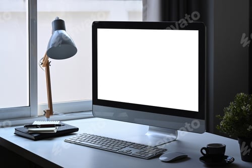 Preview: Modern workplace with computer, lamp, coffee cup and houseplant.